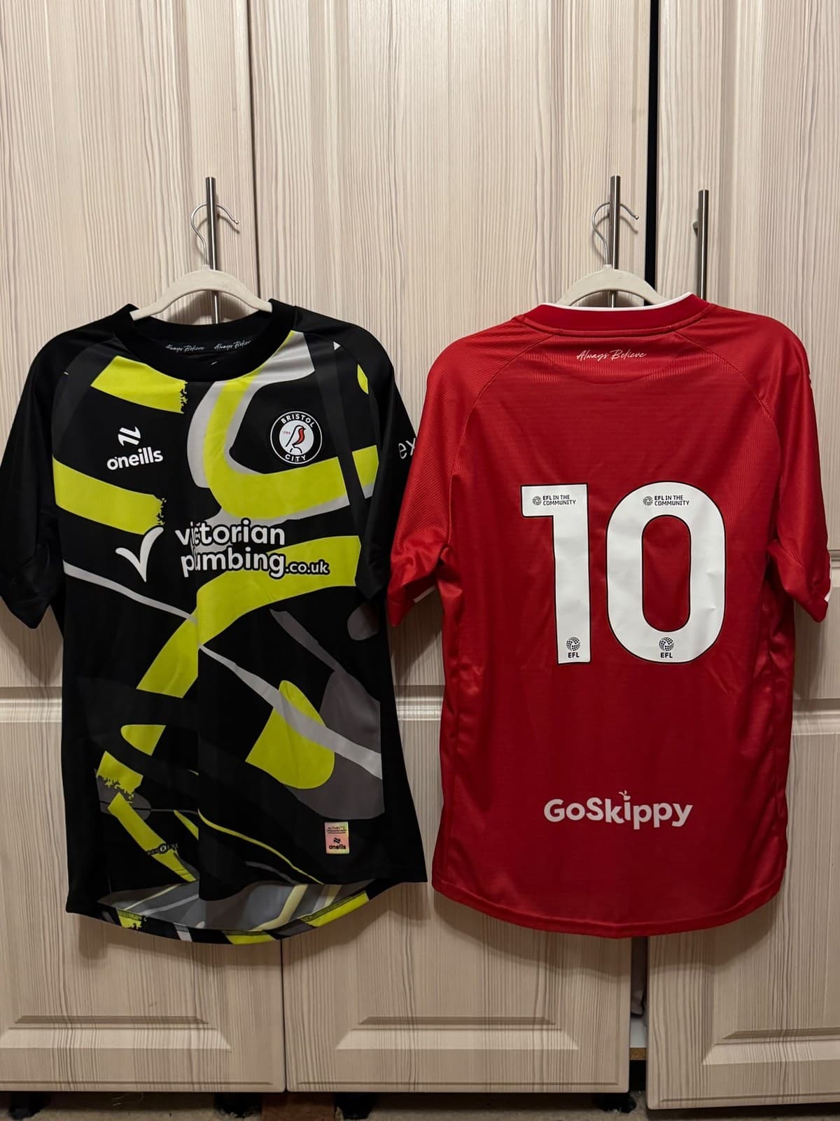 Black and yellow Bristol City goalkeeper shirt beside the red number 10 shirt